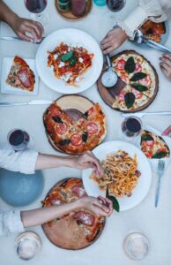 Bàn tiệc món Ý với pizza, pasta và rượu vang đỏ