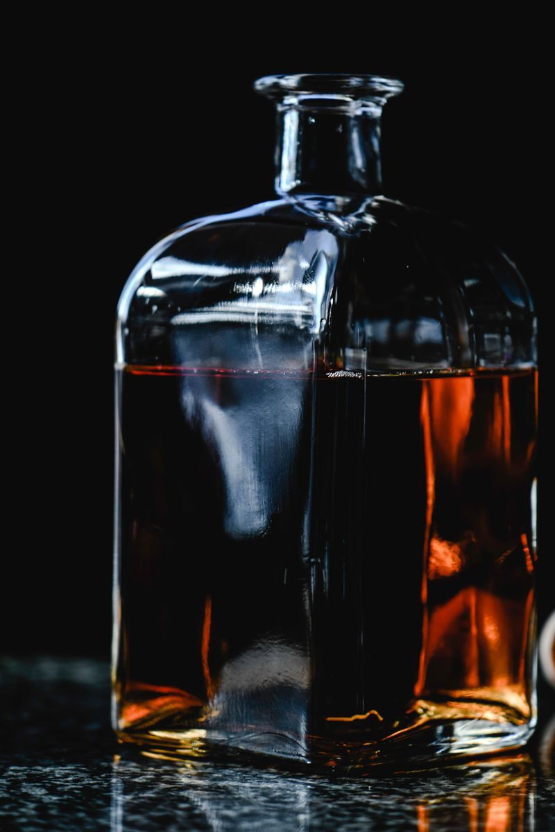 Bình decanter đựng rượu cognac màu hổ phách trên nền đen sang trọng
