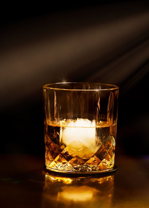 Ly whisky Chivas với đá trên quầy bar sang trọng