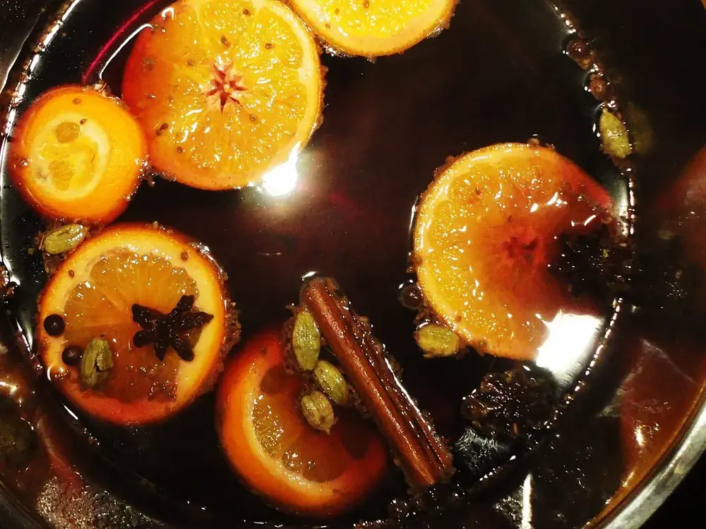 Nồi mulled wine đang nấu với cam, quế và hoa hồi