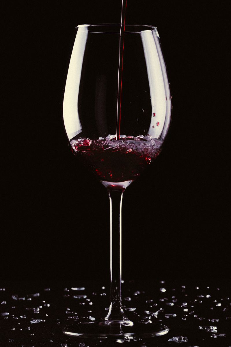 Những loại rượu vang đỏ nổi tiếng thế giới 3 Chai rượu vang đỏ Cabernet Sauvignon và ly vang trên bàn gỗ