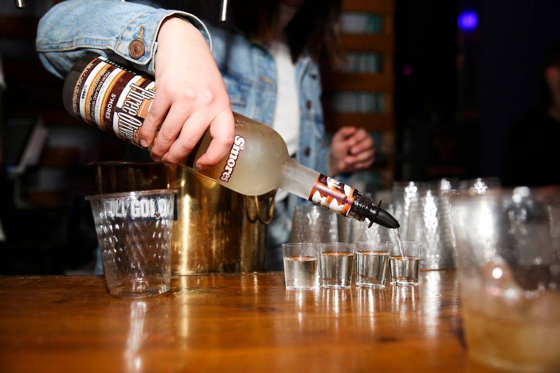 Bartender đang rót vodka vào các ly shot chuẩn bị cho bữa tiệc