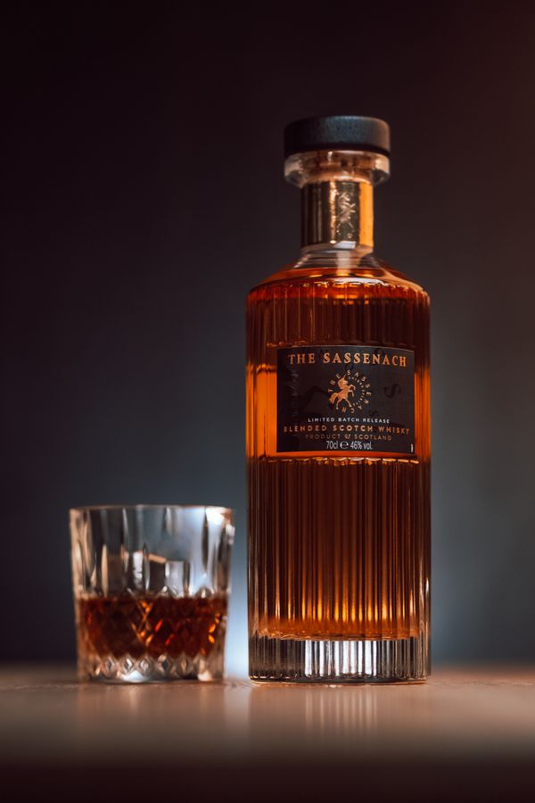 Tìm hiểu về dòng rượu Blended Whisky 2 Chai rượu blended Scotch whisky và ly rượu trên bàn